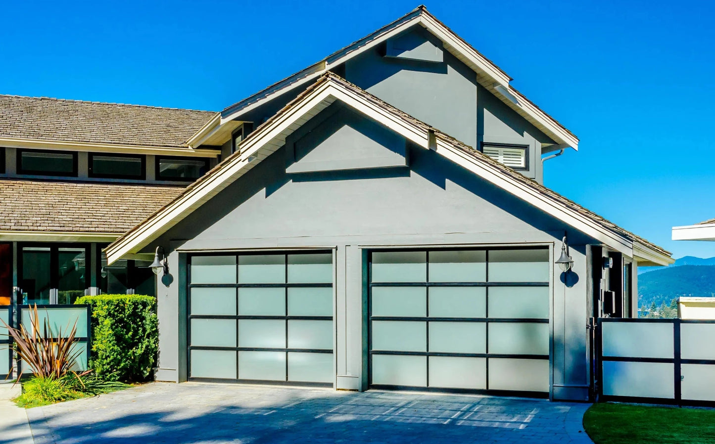 Contemporary home featuring a sleek, black garage door with large frosted glass panels, enhancing the minimalist architectural design